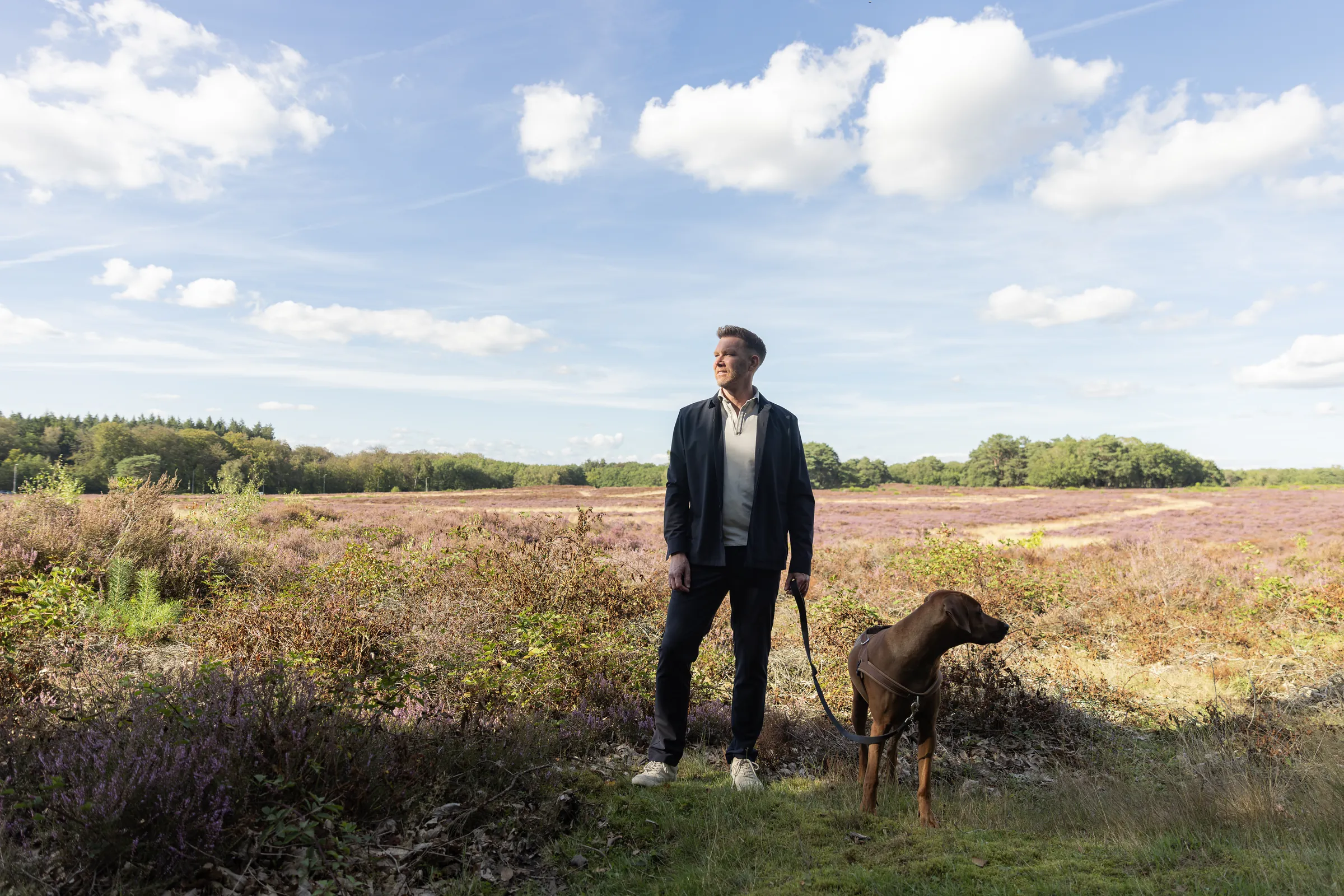 Sipke Jan Bousema met zijn hond op de heide, kijkend naar de horizon