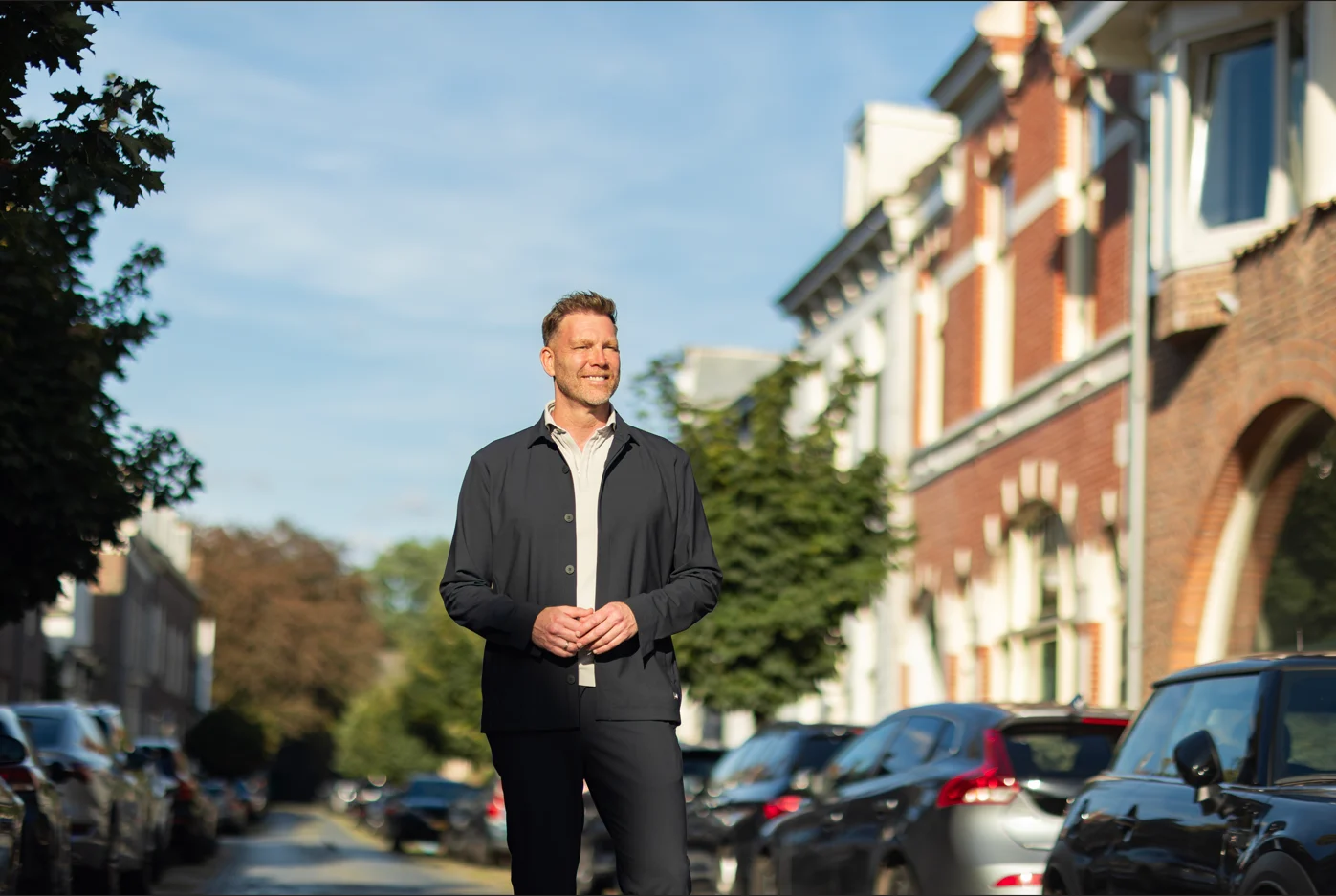 Sipke Jan Bousema staand in het midden van een rustige straat met herenhuizen